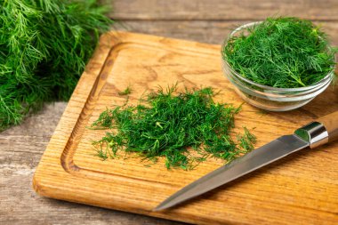 Ahşap arka planda Dill. Taze organik sebzeler. Dill çiftliği. Dereotu yapraklarını kes. Bahar genç deresi sürüsü. Vitaminler. İplik. Aromatik mutfak baharatı. Mesaj için yer. Boşluğu kopyala