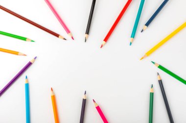 Beyaz arkaplanda izole edilmiş renkli kalemler. Boyama için ekipman. Yaratıcılık için kırtasiye malzemesi. Okula dönüyorum. Flatlay. Çocukların Yaratıcılığı ve Eğitimi. Gökkuşağı.