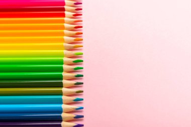 Renkli arka planda renkli kalemler. Boyama için ekipman. Yaratıcılık için kırtasiye malzemesi. Okula dönüyorum. Flatlay. Çocukların Yaratıcılığı ve Eğitimi. Rainbow.Mesaj için yer var. Boşluğu kopyala.