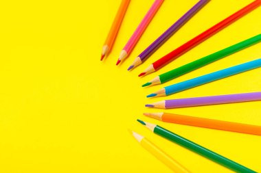 Renkli arka planda renkli kalemler. Boyama için ekipman. Yaratıcılık için kırtasiye malzemesi. Okula dönüyorum. Flatlay. Çocukların Yaratıcılığı ve Eğitimi. Rainbow.Mesaj için yer var. Boşluğu kopyala.