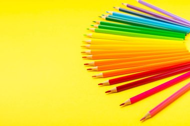 Renkli arka planda renkli kalemler. Boyama için ekipman. Yaratıcılık için kırtasiye malzemesi. Okula dönüyorum. Flatlay. Çocukların Yaratıcılığı ve Eğitimi. Rainbow.Mesaj için yer var. Boşluğu kopyala.