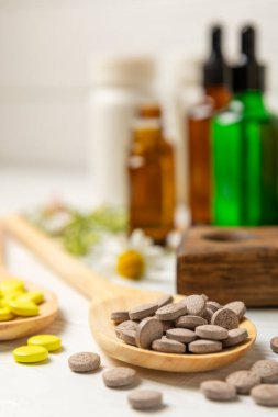 Ahşap zemin üzerinde alternatif ilaç bitkisel kapsül organik ilaç. Bitki ve tablet çeşitleri, vitaminler ve diyet takviyeleri. Sağlıklı yaşam için tıbbi ve şifalı bitkiler.