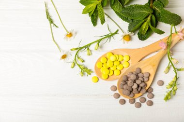 Ahşap zemin üzerinde alternatif ilaç bitkisel kapsül organik ilaç. Bitki ve tablet çeşitleri, vitaminler ve diyet takviyeleri. Sağlıklı yaşam için tıbbi ve şifalı bitkiler.