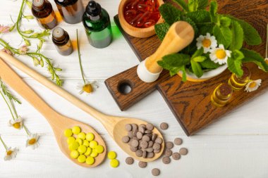 Ahşap zemin üzerinde alternatif ilaç bitkisel kapsül organik ilaç. Bitki ve tablet çeşitleri, vitaminler ve diyet takviyeleri. Sağlıklı yaşam için tıbbi ve şifalı bitkiler.