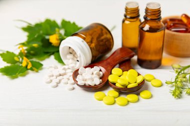 Ahşap zemin üzerinde alternatif ilaç bitkisel kapsül organik ilaç. Bitki ve tablet çeşitleri, vitaminler ve diyet takviyeleri. Sağlıklı yaşam için tıbbi ve şifalı bitkiler.