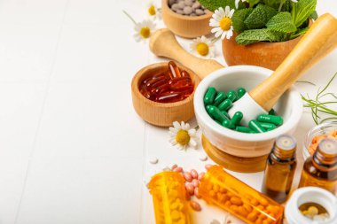 Ahşap zemin üzerinde alternatif ilaç bitkisel kapsül organik ilaç. Bitki ve tablet çeşitleri, vitaminler ve diyet takviyeleri. Sağlıklı yaşam için tıbbi ve şifalı bitkiler.