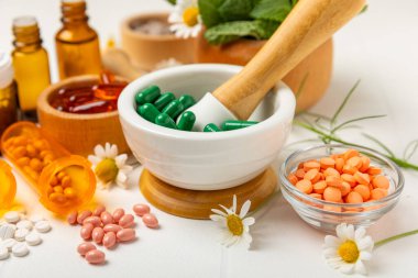 Ahşap zemin üzerinde alternatif ilaç bitkisel kapsül organik ilaç. Bitki ve tablet çeşitleri, vitaminler ve diyet takviyeleri. Sağlıklı yaşam için tıbbi ve şifalı bitkiler.