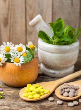 Ahşap zemin üzerinde alternatif ilaç bitkisel kapsül organik ilaç. Bitki ve tablet çeşitleri, vitaminler ve diyet takviyeleri. Sağlıklı yaşam için tıbbi ve şifalı bitkiler.