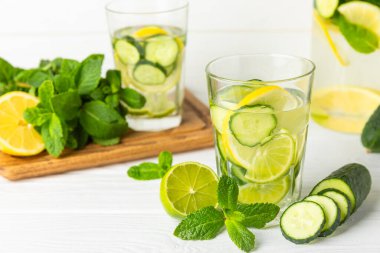 Salatalık suyu, limon, nane ve ahşap bir masada. İçme bardağında dilimlenmiş salatalık ile karıştırılmış su. Tonik ferahlatıcı bir içecek. Salatalık limonata. Doğal soğutma içeceği. Boşluğu kopyala.
