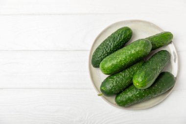 Ahşap arka planda salatalık. Arka planda bir parça salatalık. Taze organik yeşil salatalık turşusu. Vejetaryen. Salata malzemesi. Çiftlik sebzeleri. Sebzeleri bıçakla kes. Mesaj için yer var. Boşluğu kopyala