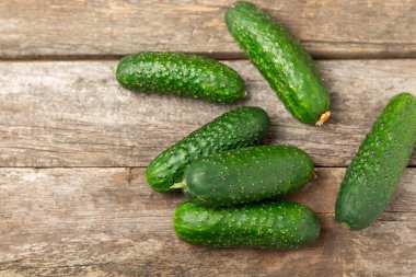 Ahşap arka planda salatalık. Arka planda bir parça salatalık. Taze organik yeşil salatalık turşusu. Vejetaryen. Salata malzemesi. Çiftlik sebzeleri. Sebzeleri bıçakla kes. Mesaj için yer var. Boşluğu kopyala