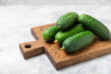 Ahşap arka planda salatalık. Arka planda bir parça salatalık. Taze organik yeşil salatalık turşusu. Vejetaryen. Salata malzemesi. Çiftlik sebzeleri. Sebzeleri bıçakla kes. Mesaj için yer var. Boşluğu kopyala