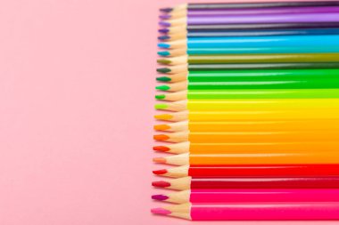 Renkli arka planda renkli kalemler. Boyama için ekipman. Yaratıcılık için kırtasiye malzemesi. Okula dönüyorum. Flatlay. Çocukların Yaratıcılığı ve Eğitimi. Rainbow.Mesaj için yer var. Boşluğu kopyala.