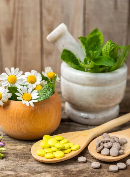 Ahşap zemin üzerinde alternatif ilaç bitkisel kapsül organik ilaç. Bitki ve tablet çeşitleri, vitaminler ve diyet takviyeleri. Sağlıklı yaşam için tıbbi ve şifalı bitkiler.