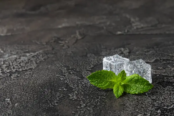Arka planda nane ve buz var. Yeşil taze nane ve buz küpü. Nane yaprağı, buz küpü ve soğuk içecek için su damlası. Üst Manzara. Mesaj için yer var. Boşluğu kopyala.