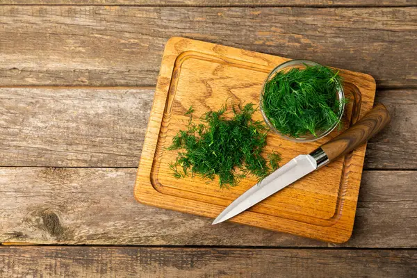 Ahşap arka planda Dill. Taze organik sebzeler. Dill çiftliği. Dereotu yapraklarını kes. Bahar genç deresi sürüsü. Vitaminler. İplik. Aromatik mutfak baharatı. Mesaj için yer. Boşluğu kopyala