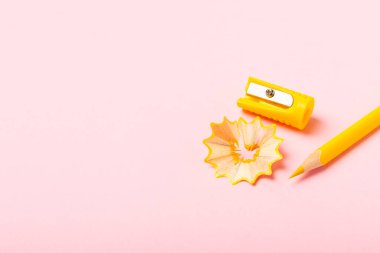 Renkli arka planda kalem açacağı. Kalem ve kalem talaşı. Kırtasiye malzemeleri. Okul malzemeleri. Okul ürünleri. Düz yatıyordu. Mesaj için yer. Boşluğu kopyala.