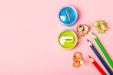 Renkli arka planda kalem açacağı. Kalem ve kalem talaşı. Kırtasiye malzemeleri. Okul malzemeleri. Okul ürünleri. Düz yatıyordu. Mesaj için yer. Boşluğu kopyala.