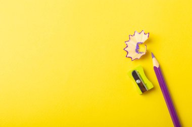 Renkli arka planda kalem açacağı. Kalem ve kalem talaşı. Kırtasiye malzemeleri. Okul malzemeleri. Okul ürünleri. Düz yatıyordu. Mesaj için yer. Boşluğu kopyala.