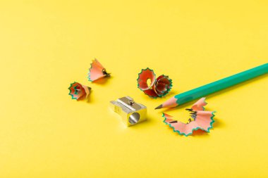 Renkli arka planda kalem açacağı. Kalem ve kalem talaşı. Kırtasiye malzemeleri. Okul malzemeleri. Okul ürünleri. Düz yatıyordu. Mesaj için yer. Boşluğu kopyala.