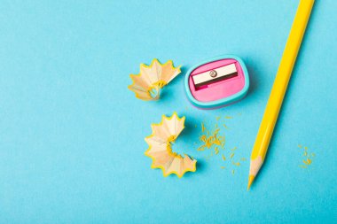 Renkli arka planda kalem açacağı. Kalem ve kalem talaşı. Kırtasiye malzemeleri. Okul malzemeleri. Okul ürünleri. Düz yatıyordu. Mesaj için yer. Boşluğu kopyala.