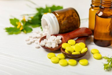 Ahşap zemin üzerinde alternatif ilaç bitkisel kapsül organik ilaç. Bitki ve tablet çeşitleri, vitaminler ve diyet takviyeleri. Sağlıklı yaşam için tıbbi ve şifalı bitkiler.