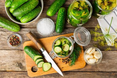 Ahşap bir arka planda kavanozda taze tuzlanmış ev yapımı salatalıklar. Dereotlu, sarımsaklı ve biberli salatalık turşusu. Konserve salatalık, salatalık ve penis. Ev yapımı koruma..