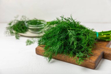 Ahşap arka planda Dill. Taze organik sebzeler. Dill çiftliği. Dereotu yapraklarını kes. Bahar genç deresi sürüsü. Vitaminler. İplik. Aromatik mutfak baharatı. Mesaj için yer. Boşluğu kopyala