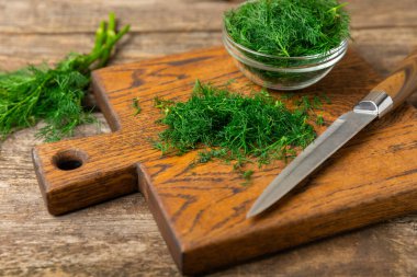 Ahşap arka planda Dill. Taze organik sebzeler. Dill çiftliği. Dereotu yapraklarını kes. Bahar genç deresi sürüsü. Vitaminler. İplik. Aromatik mutfak baharatı. Mesaj için yer. Boşluğu kopyala