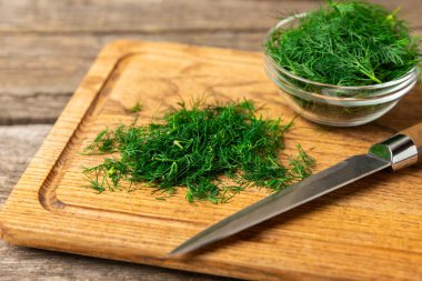 Ahşap arka planda Dill. Taze organik sebzeler. Dill çiftliği. Dereotu yapraklarını kes. Bahar genç deresi sürüsü. Vitaminler. İplik. Aromatik mutfak baharatı. Mesaj için yer. Boşluğu kopyala