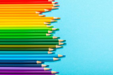 Renkli arka planda renkli kalemler. Boyama için ekipman. Yaratıcılık için kırtasiye malzemesi. Okula dönüyorum. Flatlay. Çocukların Yaratıcılığı ve Eğitimi. Rainbow.Mesaj için yer var. Boşluğu kopyala.