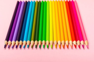 Renkli arka planda renkli kalemler. Boyama için ekipman. Yaratıcılık için kırtasiye malzemesi. Okula dönüyorum. Flatlay. Çocukların Yaratıcılığı ve Eğitimi. Rainbow.Mesaj için yer var. Boşluğu kopyala.