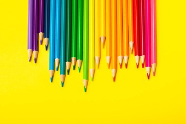 Renkli arka planda renkli kalemler. Boyama için ekipman. Yaratıcılık için kırtasiye malzemesi. Okula dönüyorum. Flatlay. Çocukların Yaratıcılığı ve Eğitimi. Rainbow.Mesaj için yer var. Boşluğu kopyala.