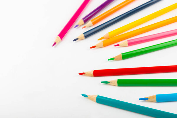 Цветные карандаши изолированы на белом фоне. Оборудование для окраски. Канцелярские принадлежности для творчества. Флэтли. Детское творчество и образование. Радуга.