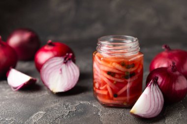 Masadaki cam kavanozda soğan turşusu. Kırmızı soğan turşusu. Vejetaryen baharatlı yemek. Lezzetli ev yapımı marine edilmiş mor soğan turşusu. Mesaj için yer var. Boşluğu kopyala.