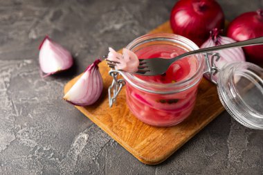 Masadaki cam kavanozda soğan turşusu. Kırmızı soğan turşusu. Vejetaryen baharatlı yemek. Lezzetli ev yapımı marine edilmiş mor soğan turşusu. Mesaj için yer var. Boşluğu kopyala.