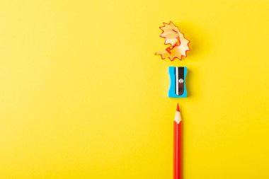 Renkli arka planda kalem açacağı. Kalem ve kalem talaşı. Kırtasiye malzemeleri. Okul malzemeleri. Okul ürünleri. Düz yatıyordu. Mesaj için yer. Boşluğu kopyala.