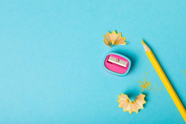 Renkli arka planda kalem açacağı. Kalem ve kalem talaşı. Kırtasiye malzemeleri. Okul malzemeleri. Okul ürünleri. Düz yatıyordu. Mesaj için yer. Boşluğu kopyala.