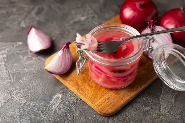 Masadaki cam kavanozda soğan turşusu. Kırmızı soğan turşusu. Vejetaryen baharatlı yemek. Lezzetli ev yapımı marine edilmiş mor soğan turşusu. Mesaj için yer var. Boşluğu kopyala.