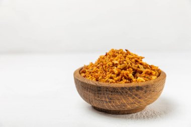 Tahta bir masada kasede kızarmış soğan. Kızarmış soğan. Bulaşık çeşnisi. Baharatlar. Salata sosu. Mesaj için yer var. Boşluğu kopyala