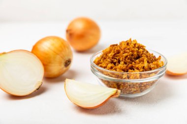 Tahta bir masada kasede kızarmış soğan. Kızarmış soğan. Bulaşık çeşnisi. Baharatlar. Salata sosu. Mesaj için yer var. Boşluğu kopyala