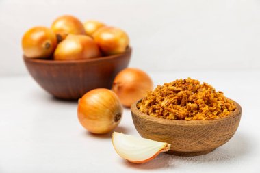 Tahta bir masada kasede kızarmış soğan. Kızarmış soğan. Bulaşık çeşnisi. Baharatlar. Salata sosu. Mesaj için yer var. Boşluğu kopyala