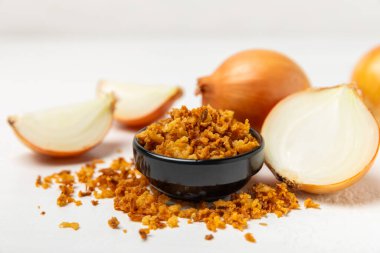 Tahta bir masada kasede kızarmış soğan. Kızarmış soğan. Bulaşık çeşnisi. Baharatlar. Salata sosu. Mesaj için yer var. Boşluğu kopyala