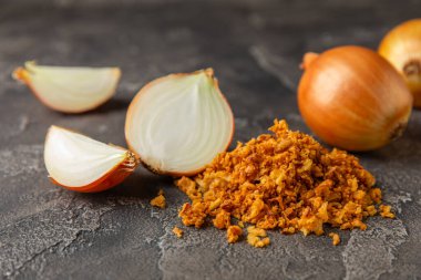 Tahta bir masada kasede kızarmış soğan. Kızarmış soğan. Bulaşık çeşnisi. Baharatlar. Salata sosu. Mesaj için yer var. Boşluğu kopyala