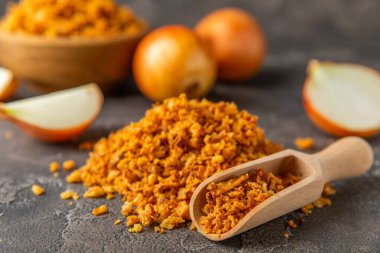 Tahta bir masada kasede kızarmış soğan. Kızarmış soğan. Bulaşık çeşnisi. Baharatlar. Salata sosu. Mesaj için yer var. Boşluğu kopyala