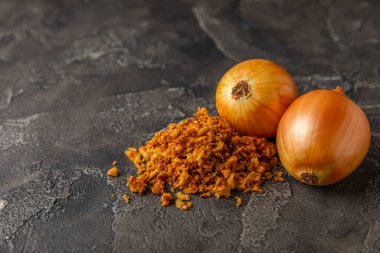 Tahta bir masada kasede kızarmış soğan. Kızarmış soğan. Bulaşık çeşnisi. Baharatlar. Salata sosu. Mesaj için yer var. Boşluğu kopyala