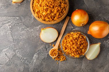 Tahta bir masada kasede kızarmış soğan. Kızarmış soğan. Bulaşık çeşnisi. Baharatlar. Salata sosu. Mesaj için yer var. Boşluğu kopyala