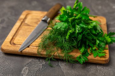 Doku masasında Dill ve Maydanoz. Maydanozla dereotu karıştırdım. Taze aromalı baharatlı sebzeler. Baharatlar ve bitkiler. Mesaj için yer var. Boşluğu kopyala