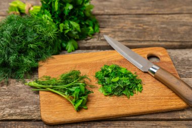 Doku masasında Dill ve Maydanoz. Maydanozla dereotu karıştırdım. Taze aromalı baharatlı sebzeler. Baharatlar ve bitkiler. Mesaj için yer var. Boşluğu kopyala