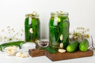 Ahşap bir arka planda kavanozda taze tuzlanmış ev yapımı salatalıklar. Dereotlu, sarımsaklı ve biberli salatalık turşusu. Konserve salatalık, salatalık ve penis. Ev yapımı koruma..